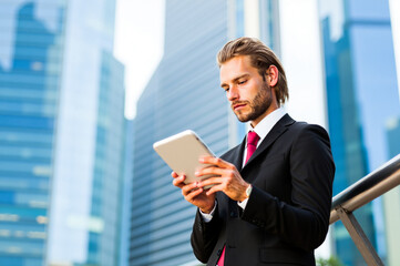 Fototapeta premium Businessman using digital tablet in front of city skyline