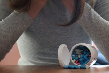 Drug abuse and dependence; a photo of a woman sitting with medication; Stop taking medications