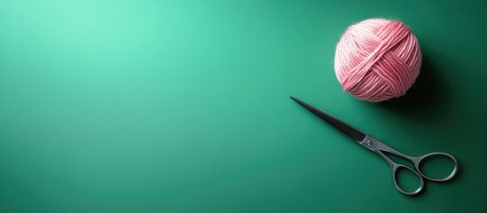 Pacific pink yarn skein against a vibrant green background with scissors. with copy space image. Place for adding text or design