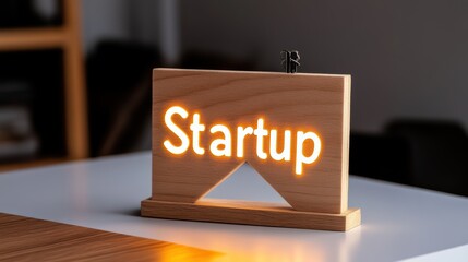 Startup Sign: A wooden sign with the word "Startup" illuminated in warm white light, signifying new beginnings and entrepreneurial spirit.  