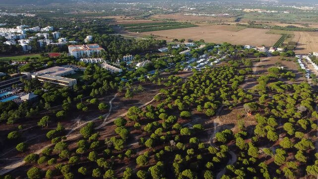 Aerial view of south of Portugal landscape. Hotels and urbanisations. View of Campings for motorhomes. Algarve region. Drone going forward. Famous travel destination.