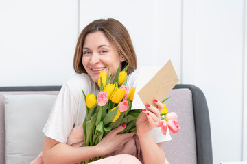 A young beautiful girl received a bouquet of flowers and a congratulatory letter on a wonderful...