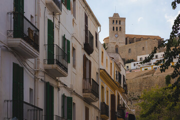 Scenic view of historic Dalt Vila and charming white buildings with green shutters in Ibiza’s Old Town, capturing Mediterranean elegance and cultural heritage.