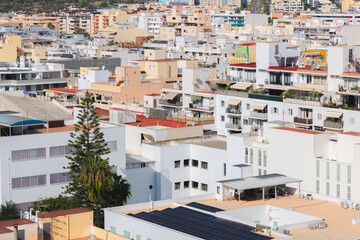 Fototapeta premium Urban cityscape of Ibiza Town, Spain with whitewashed buildings, showcasing Mediterranean architecture under a bright summer sky.