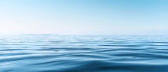  A large body of water with a blue sky and a distant island in the distance