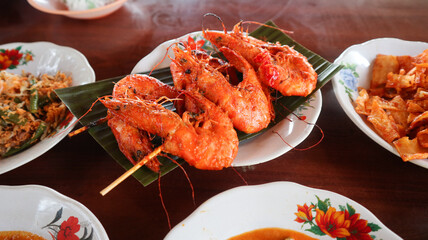 Udang Bakar, Grilled Shrimp, made from shrimp seasoned with chilli sauce, and pepper. served with other food at restaurant