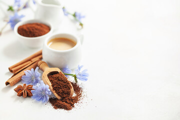 Diet drink chicory in a cup - coffee substitutes, powder and flowers on the white background.