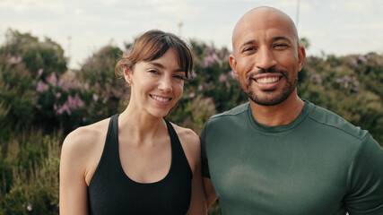 Close up of young cheerful couple in love standing outdoors in summer. Sweet lovely moment, a fit couple walking and cuddling. Couple goals and motivation