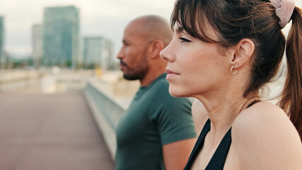 Fototapeta premium Male and female athletes in summer exercises their shoulders for muscle strength and talking, enjoy teamwork, couple goals and motivation. Happy fit people are cheerfully doing sports