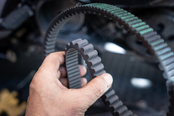 Motorcycle mechanic check the condition of motorcycle transmission belt for broken teeth,working at garage, maintenance and repair motorcycle concept