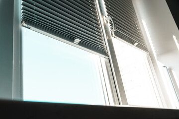 Obraz premium Gray blackout roller blinds on window indoors, closeup.