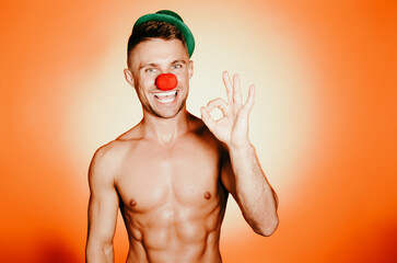 Young muscular man in a clown costume.