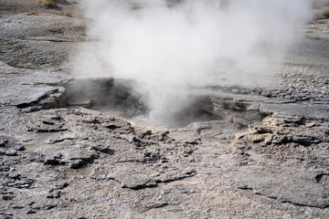 an active geyser spring with an intermittent discharge of water ejected turbulently and accompanied...