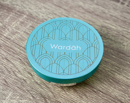 Jakarta, Indonesia - October 24th, 2024 - Wardah Exclusive Two Way Cake compact face powder packaging isolated on horizontal ratio brown wooden table background.