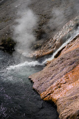 an active geyser spring with an intermittent discharge of water ejected turbulently into a river