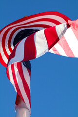 American flag blowing in the wind on the blue sky background