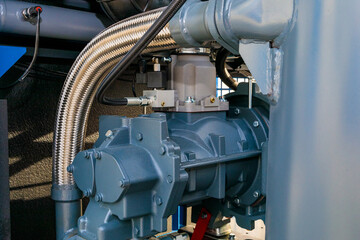 Screw compressor with flexible metal hose being used in industrial setting