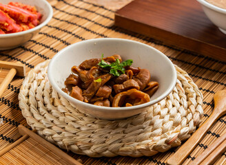 Braised large intestine with chopsticks and spoon served in bowl isolated on mat side view of taiwan food