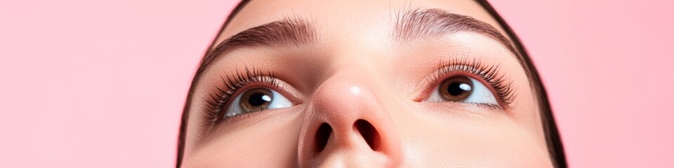 Obraz premium Woman's face in close-up, highlighting her long eyelashes and perfect skin against a vibrant pink background, perfect for beauty and cosmetics ads with plenty of space for text, banner