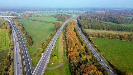 Aerial view on the A7 motorway in northern Germany between fields and meadows.