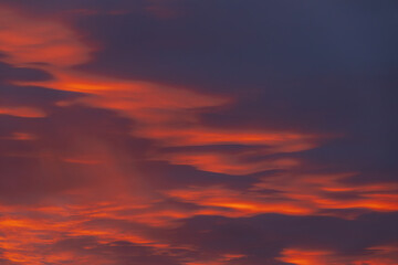 A captivating sky at sunset with dark red and orange clouds, creating a striking and moody atmosphere. The layered clouds add depth and intensity to the scene.