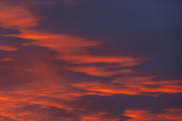 A captivating sky at sunset with dark red and orange clouds, creating a striking and moody atmosphere. The layered clouds add depth and intensity to the scene.
