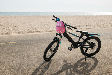 Children's bicycle on a California beach set against a backdrop of clear sky and water waves...