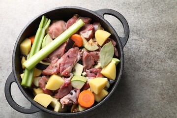 Cooking stew. Uncooked meat and vegetables in pot on light grey table, top view