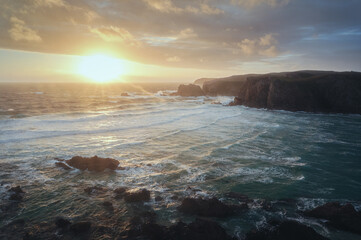 Stunning sunset over the sea at a rocky beach