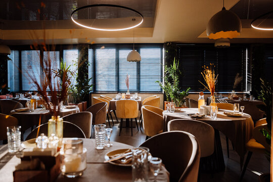 Elegant restaurant interior with natural light, cozy decor, and stylish table settings
