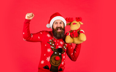 Christmas mood. its christmas time. happy bearded man in sweater. gifts and presents preparation. new year party. mature and brutal hipster in santa claus hat. surprise for xmas holiday
