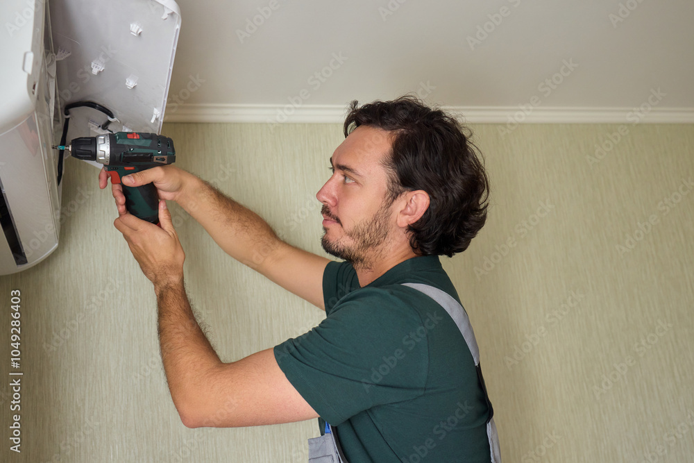 Poster a skilled professional worker is installing a ceiling appliance using a power drill tool