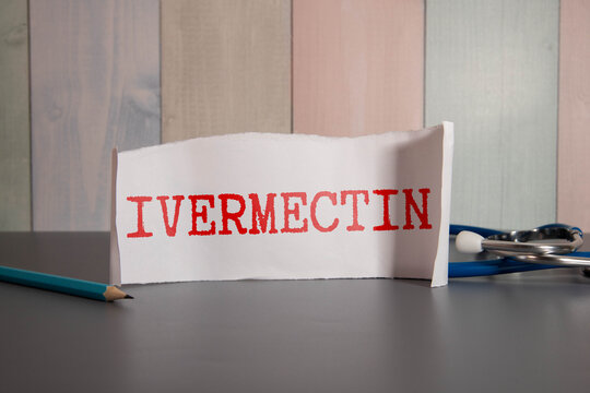 Doctor holding a card with text TREATMENT IS IVERMECTIN, medical concept.