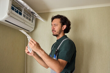 A skilled HVAC Technician is checking the air conditioner filter for performance and efficiency