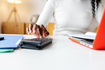 Fototapeta premium Close up of female accountant using calculator working at home office calculating business expenses