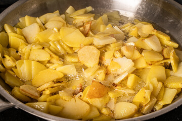 Potatoes are fried in a pan close-up. Background with potato texture