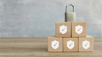 Security Concept: Wooden Blocks with Shield and Checkmark Icons Stacked with Padlock on Top