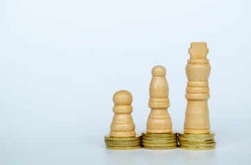 Chess pawns on top of golden stacking coins with customizable space for text