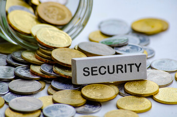 Security text on white wooden block with coins and jar background. Life security concept