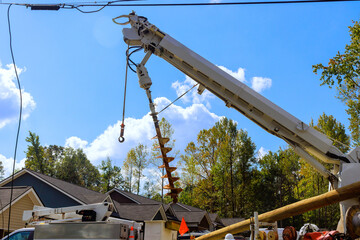 Electrical infrastructure is being upgraded by worker in a raised platform lift truck