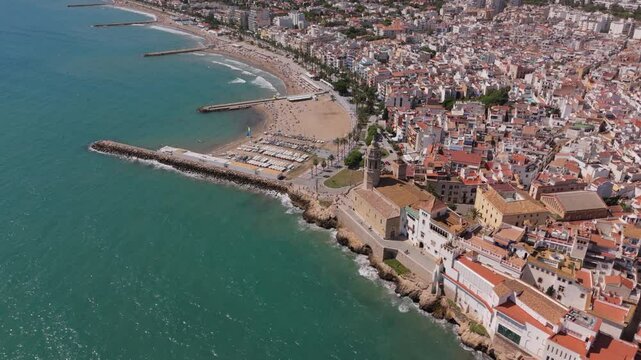Aerial view of Sitges coastal village and Iglesia de San Bartolome y Santa Tecla during a sunny day