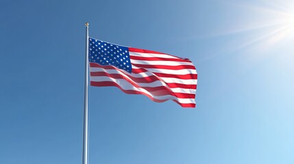 Fototapeta premium The American flag waving proudly in the wind against a clear blue sky with sun shining brightly.