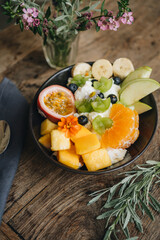 High angle view of smoothie bowl with fresh fruits on top in plate on table