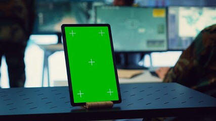 General headquarters monitoring room with a mockup screen on tablet, army officers safeguarding the...
