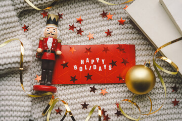A cheerful holiday greeting reads Happy Holidays surrounded by a nutcracker figurine and colorful...