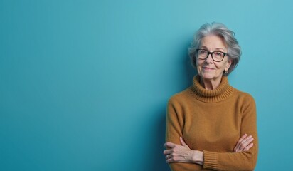 Senior woman with confident smile posing against turquoise background with copy space