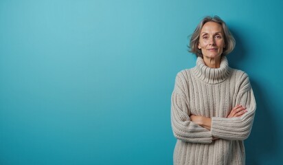 Mature Woman Confidently Smiling in Cozy Sweater Against Turquoise Background with Copy Space