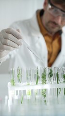 Man scientist wearing a lab coat, white gloves and protective glasses, is dripping liquid from a...