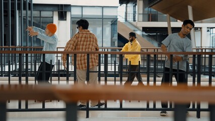 Multicultural hipster group walking while dancing at modern corridor. Attractive break dance team happy and joy while moving to hip-hop music. Active. Site view. Outdoor sport 2024. Hiphop.