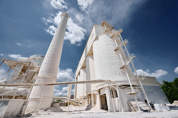 Concrete silos for limestone storage under cloudy sky